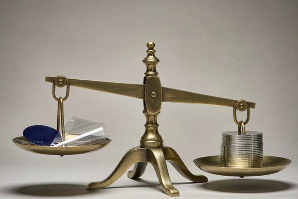 A balance scale weighing performance against cost for solar films